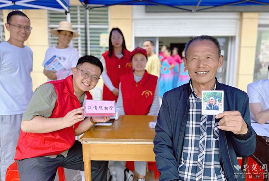 “溫情照相館”攤位上，前來照相的老人與志愿者開心地合影留念_副本.jpg