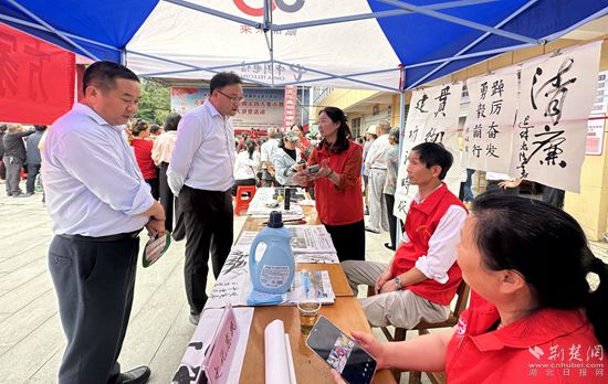 “文化惠民”攤位上，志愿者展示書法作品_副本.jpg